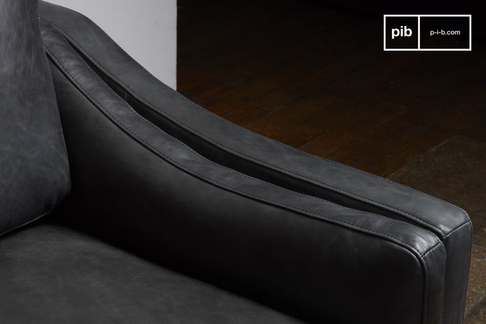 Das Sofa bietet feste Armkissen, die sich harmonisch an die leicht geschwungene Form anlehnen