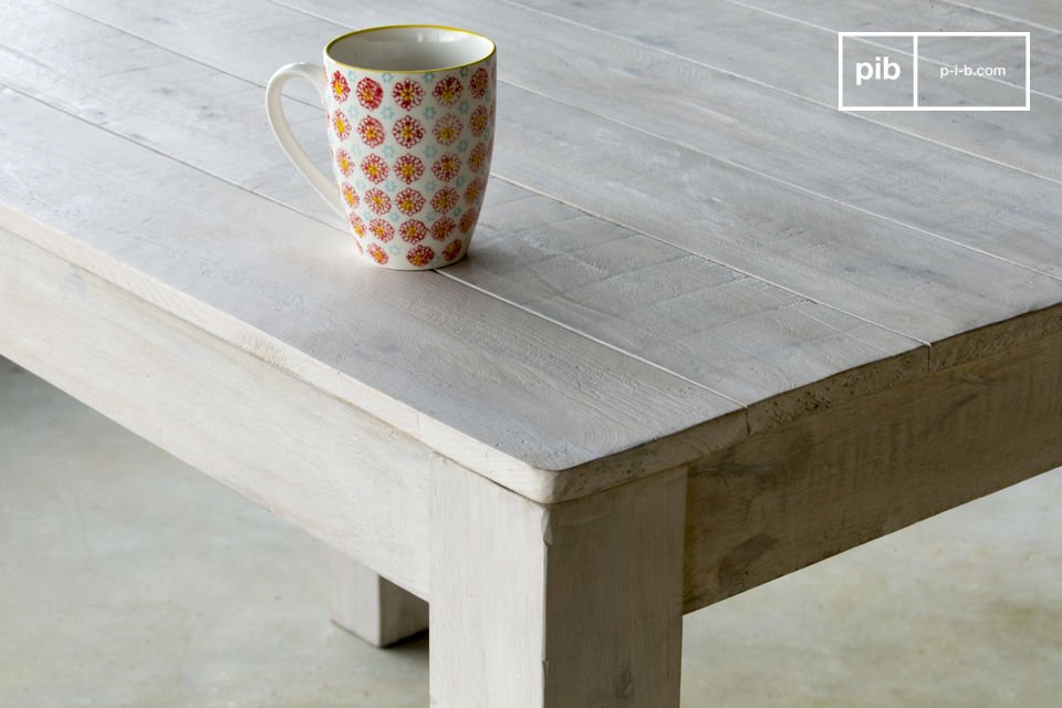 Der Holztisch besitzt mit seiner weiß patinierten Lasur und seinen zeitlos schlichten Formen