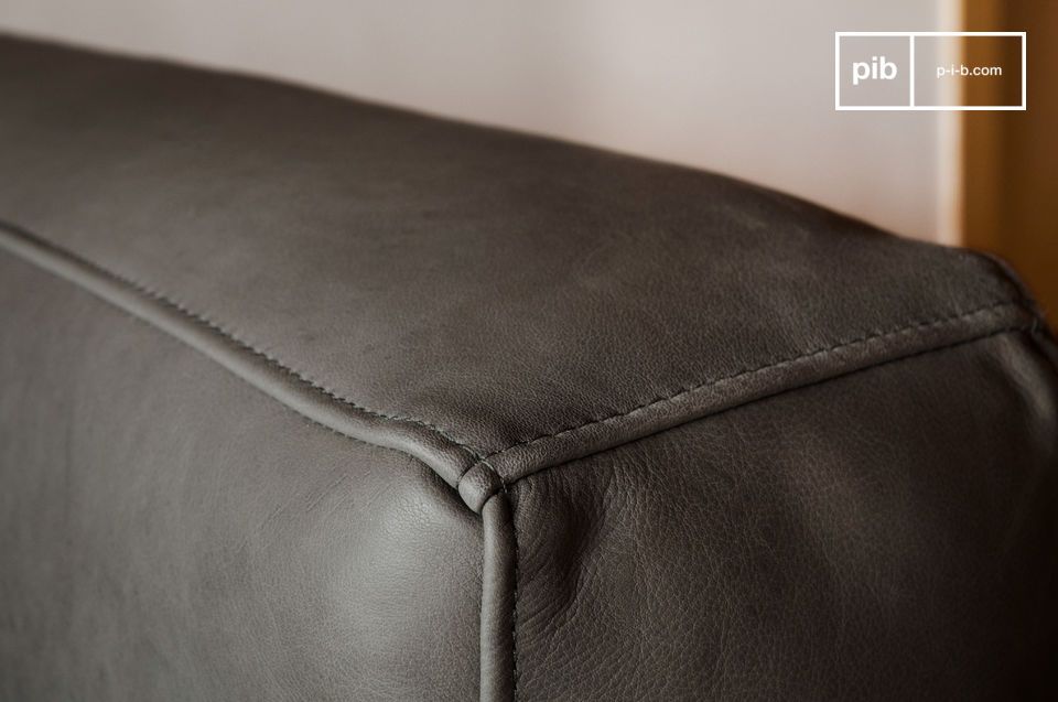Mit seinen Vintage-Linien aus den 60er Jahren und seiner grauen Lederhülle gleicht dieses Sofa die