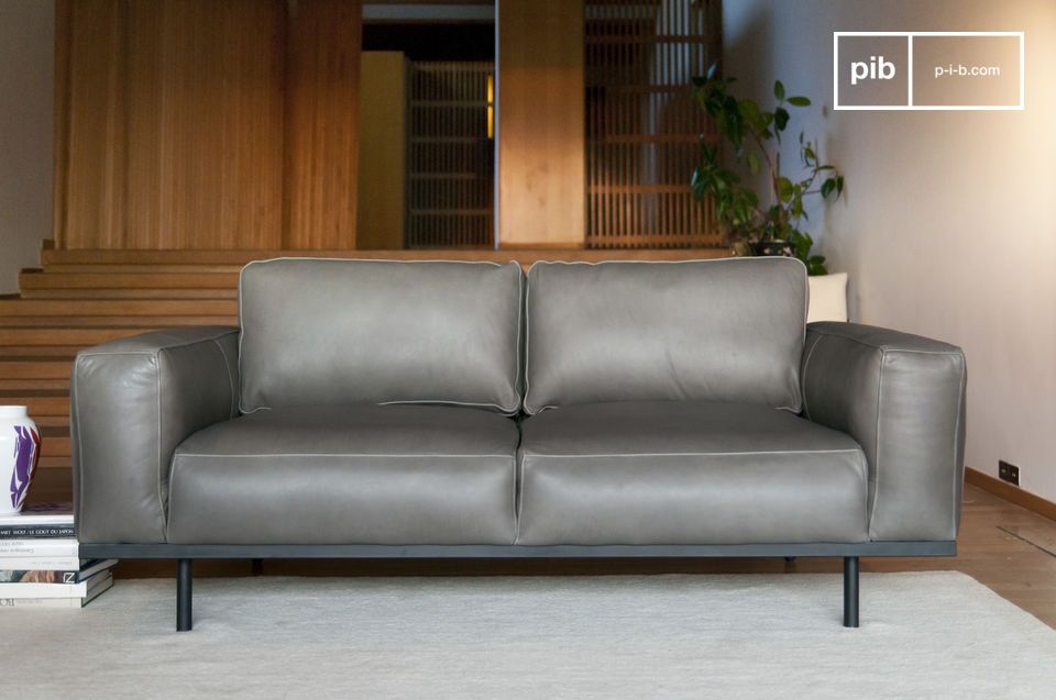 Ein harmonisch gestaltetes Sofa, das durch schöne Grautöne bereichert wird.